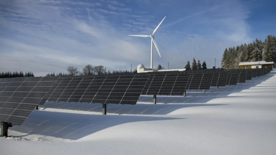 Naturen täckt av snö, blå himmel och solpaneler