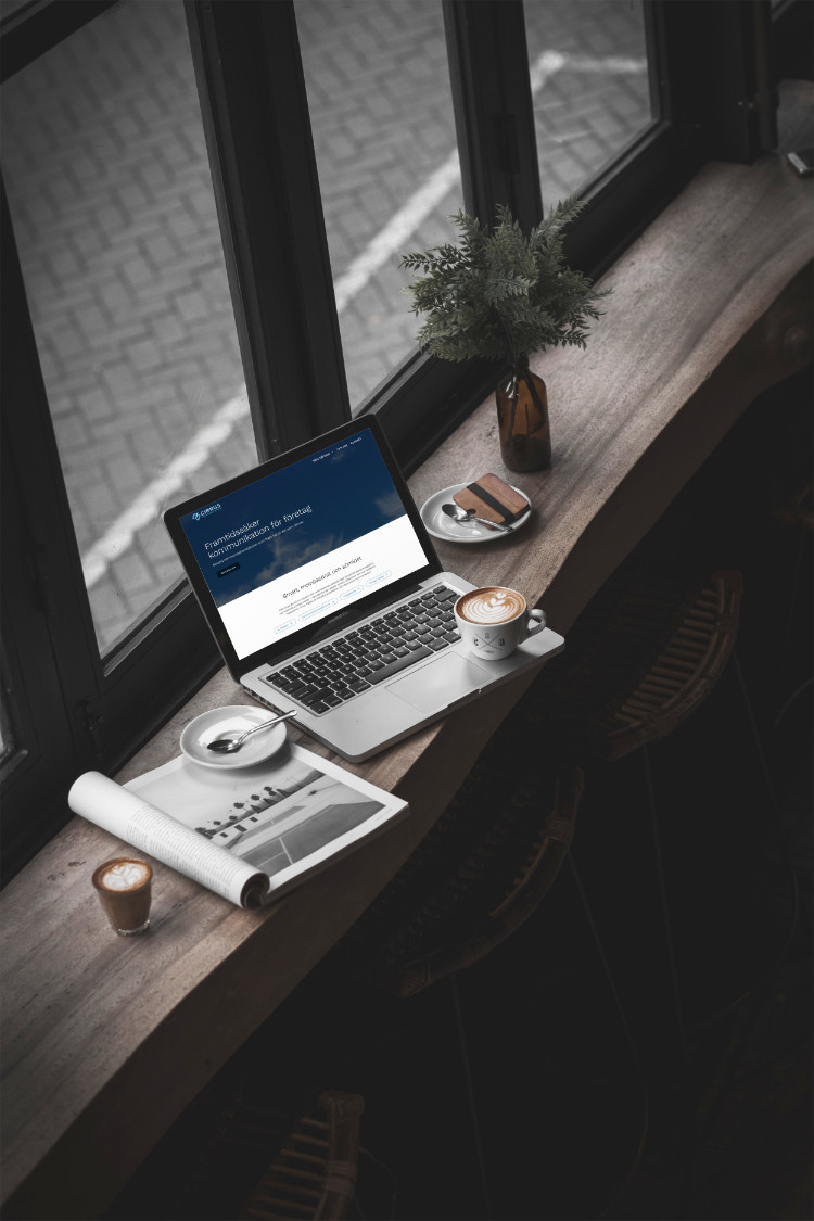 Kafémiljö som visar Cirrus Coms hemsida på en laptop